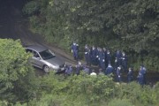 Japanese police search the mountain area where the victim's body was found.